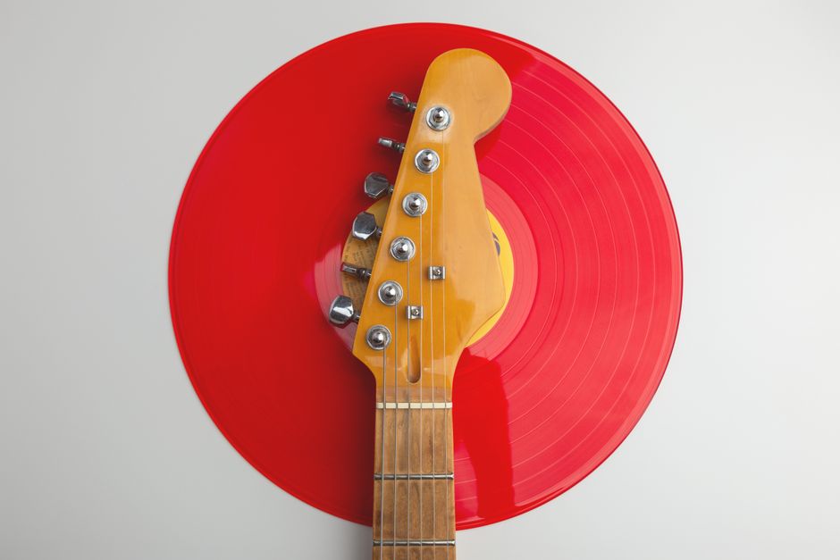 Creative close-up of an electric guitar headstock with a red vinyl record. Perfect for music-themed designs.